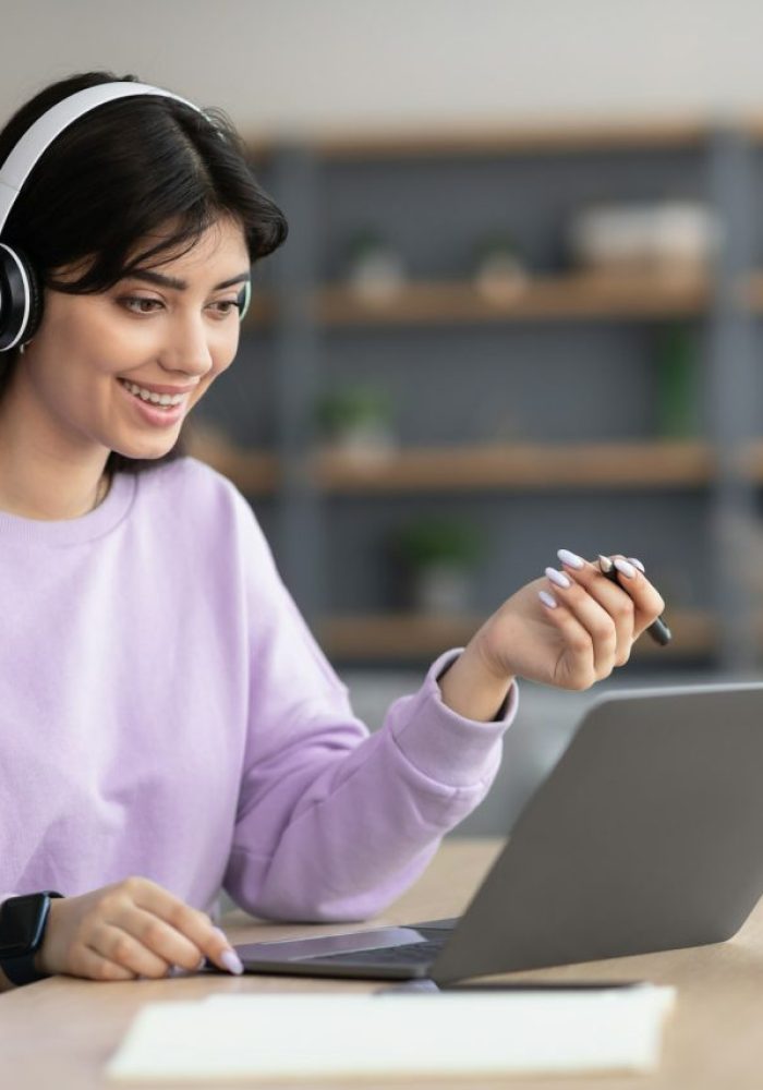 woman-in-headphones-having-video-call-using-laptop-and-talking.jpg